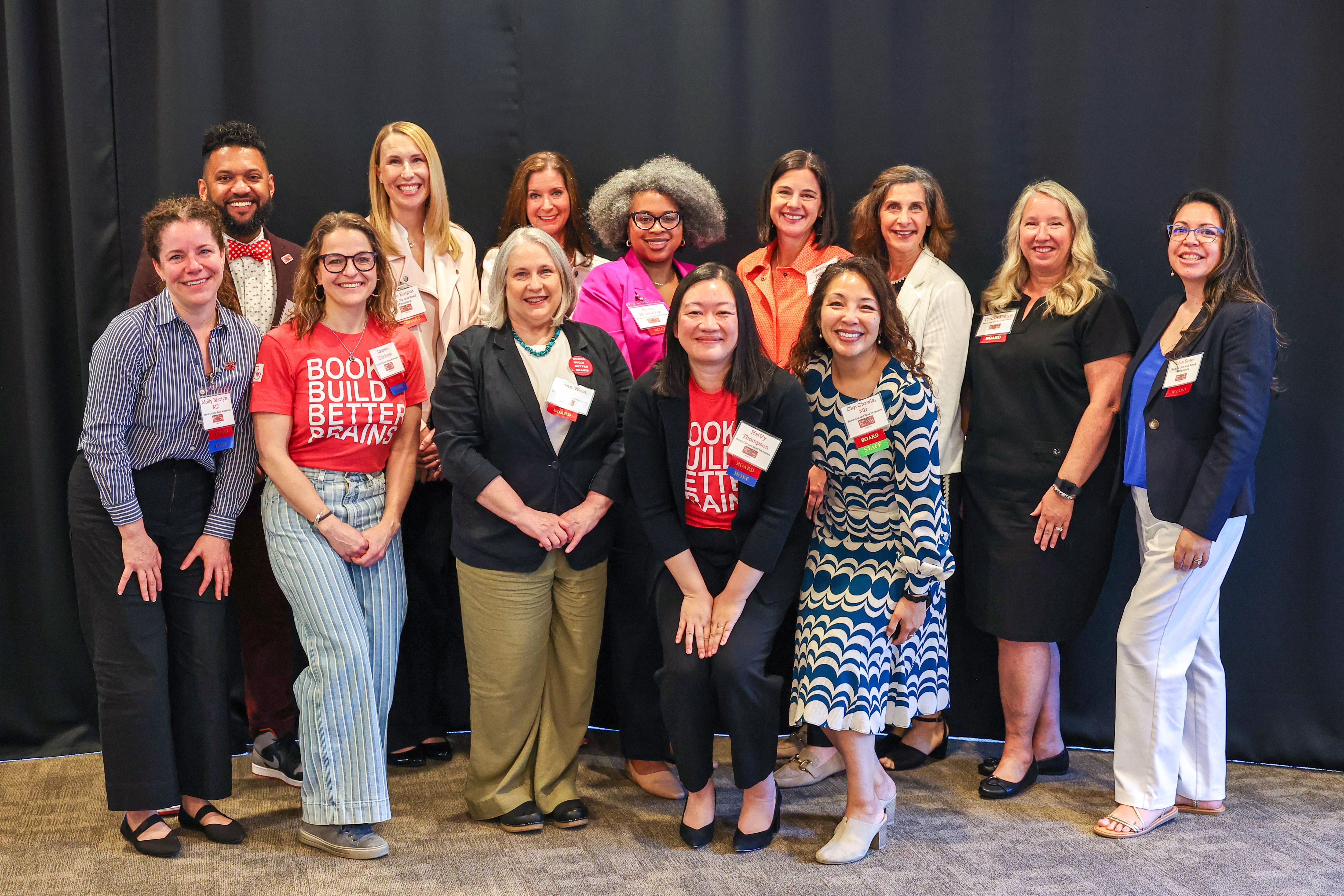 a group of 13 people, board members for Reach Out and Read Minnesota, smile standing together