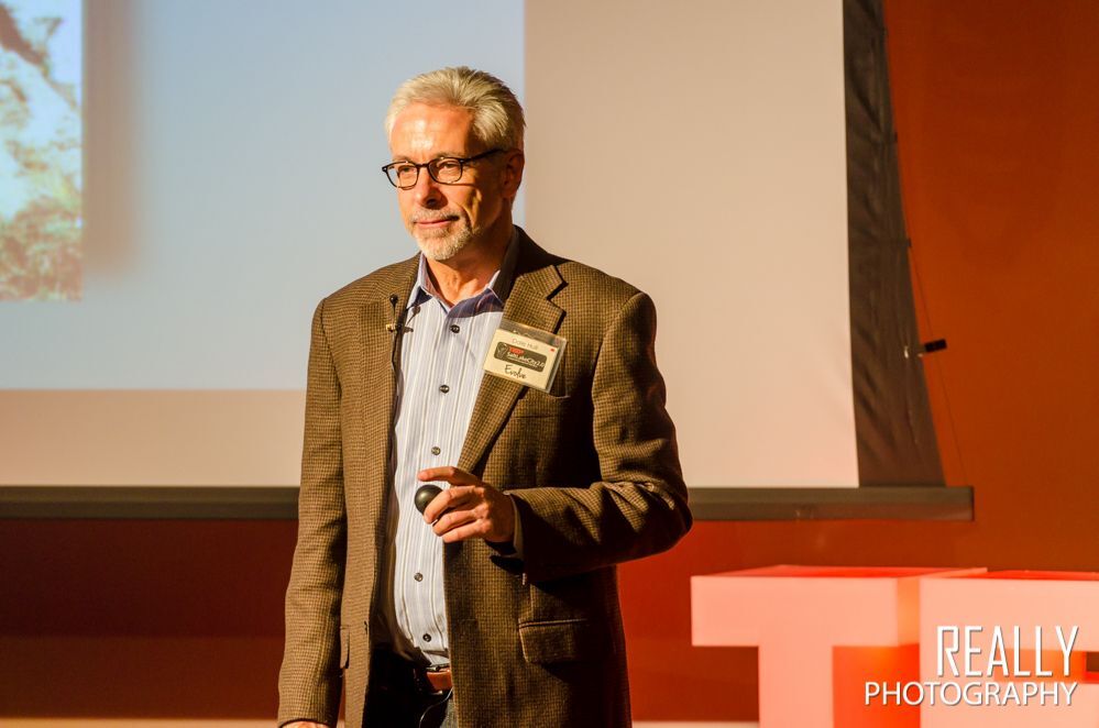 Man speaking from a stage standing