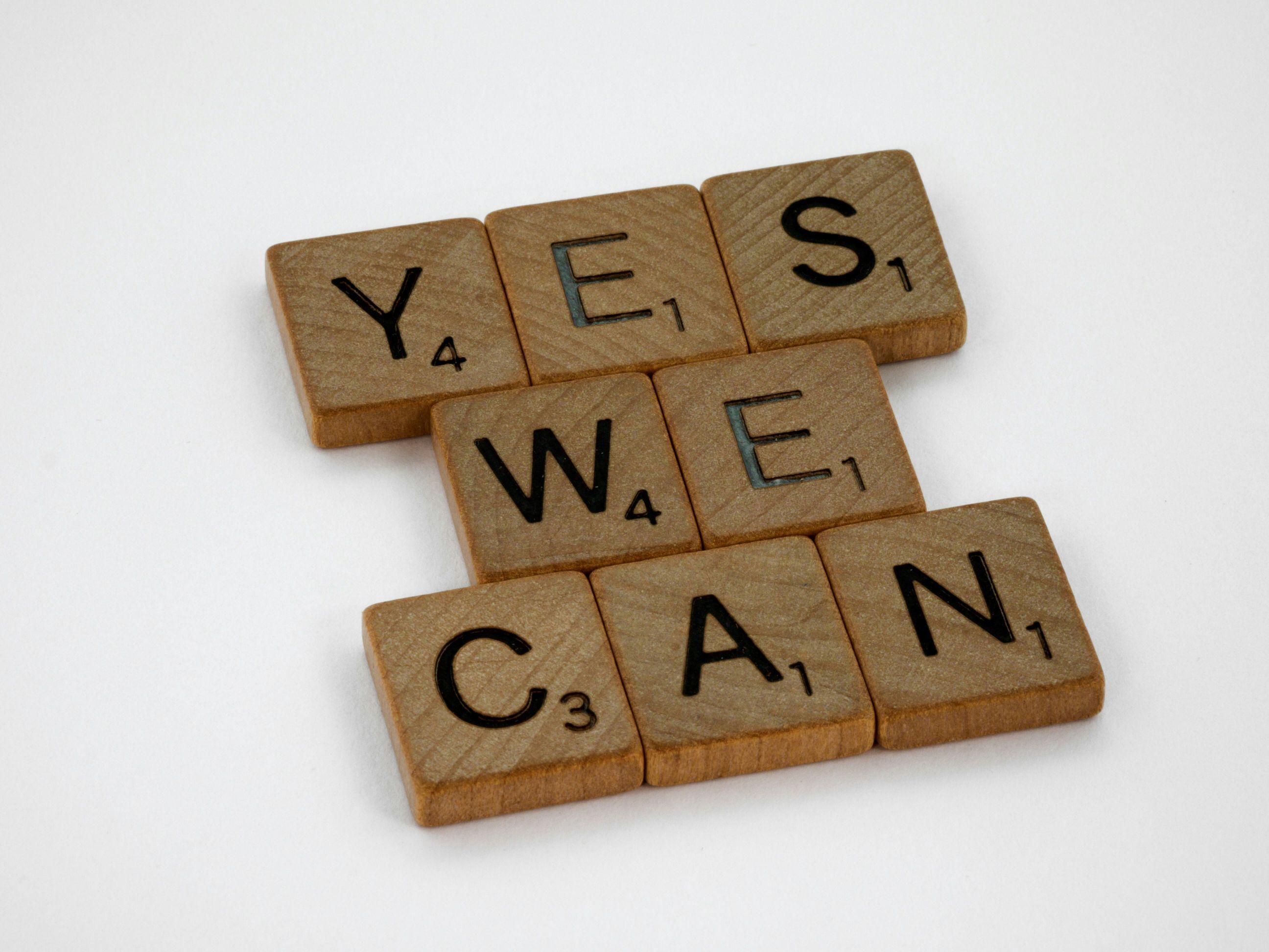 Brown wooden letter titles arranged to spell out the phrase "Yes we can."