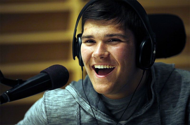 Picture of a man smiling in front of a microphone