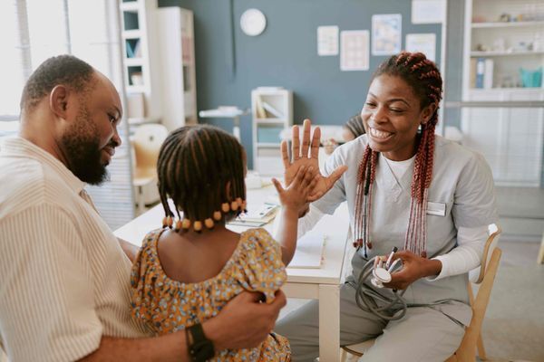 A human services worker high-fiving a child client