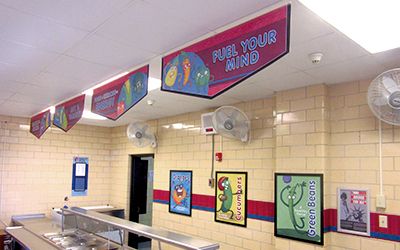 4 food banners hanging above school serving line with food characters, school banners, Breakfast = Success