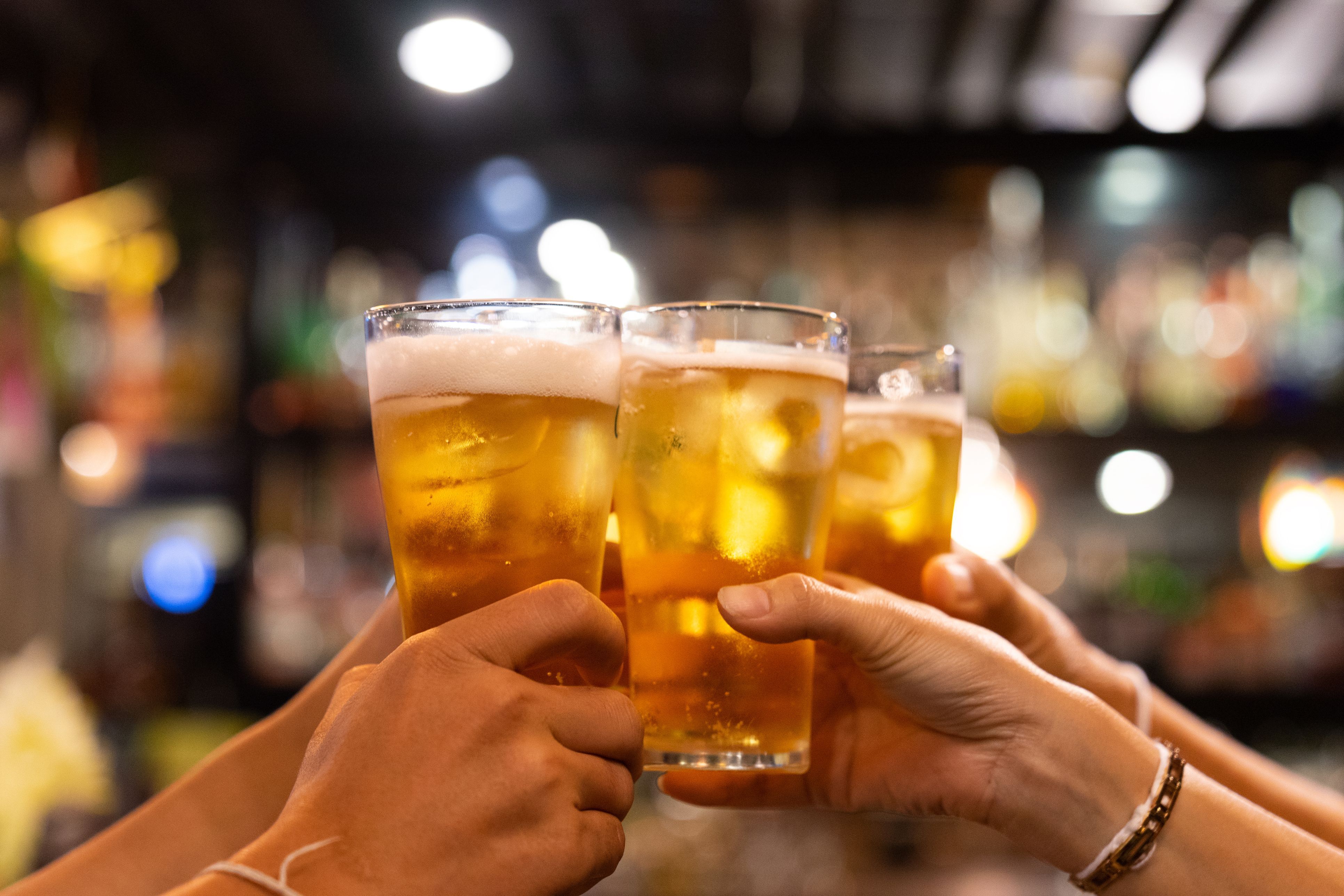 Image of people clinking glasses during happy hour