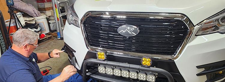 Worker installing chrome delete on vehicle