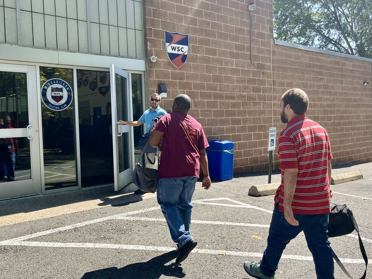 Two adults photographed walking into their new job at Wissahickon Skating Rink.