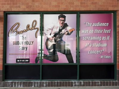 Large front door banner printed for New Theatre Restaurant's showing of "Buddy: The Buddy Holly Story".