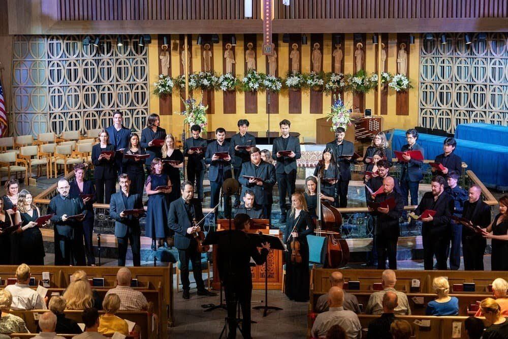 Thirteen Seraphic Fire singers joined by students from UCLA and University of Miami and a period instrument ensemble perform onstage in a church venue.