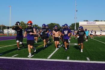 group of football players jogging across football field