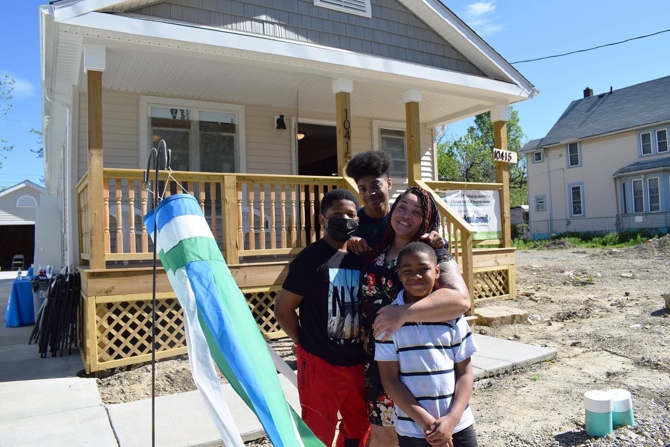 A family served by Habitat for Humanity, Greater Cleveland stands proudly in front of their new home. 