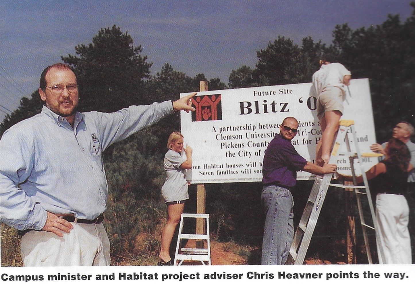 Pastor Chris Heavner of Clemson points to a sign on-site of the Blitz Build. 