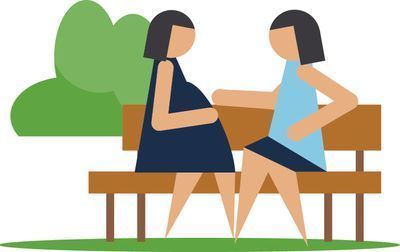 image of pregnant person and friend talking on a park bench