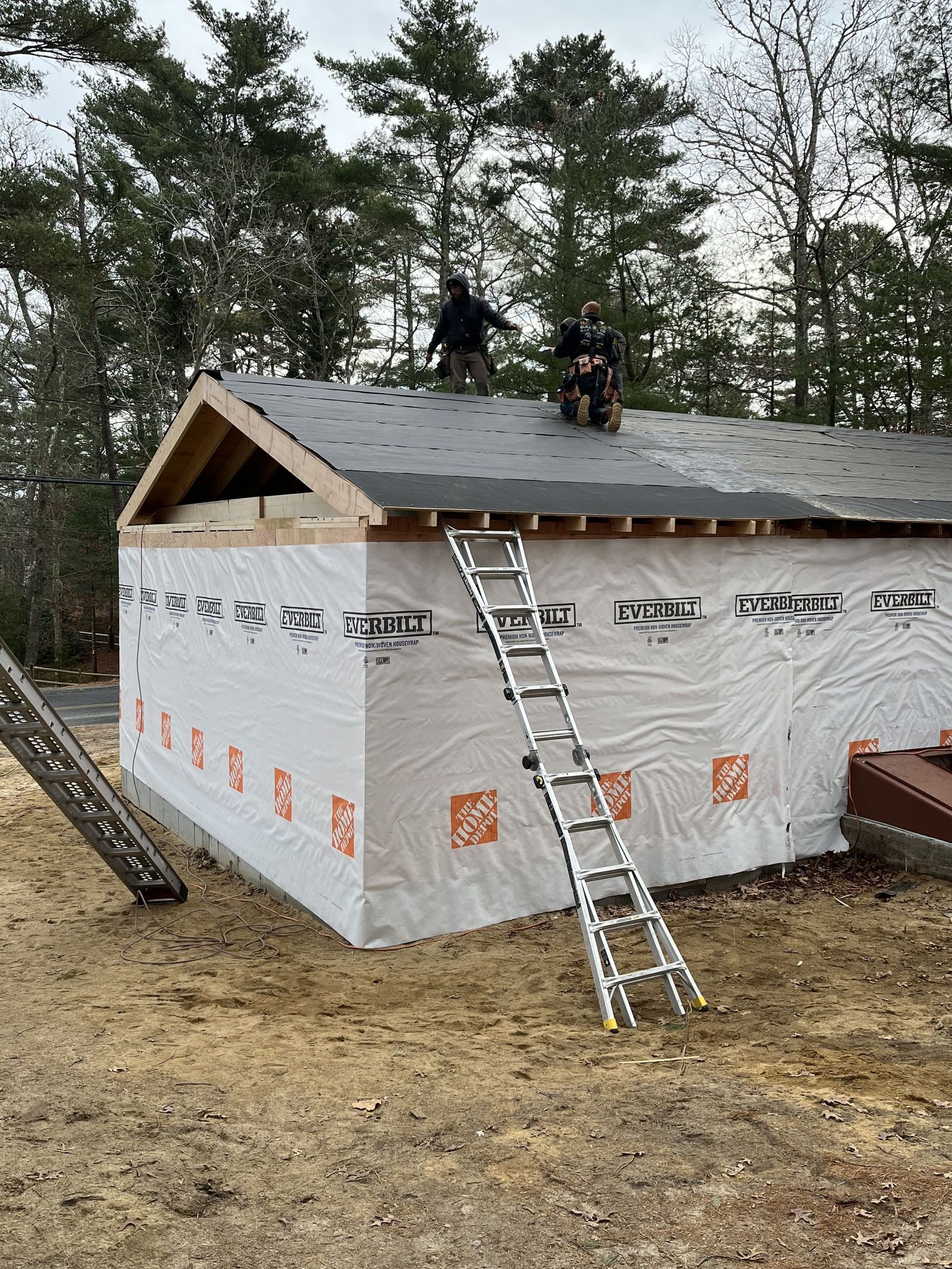 Photo of exterior of house showing new roof has been installed on the addition, connecting it to the existing structure