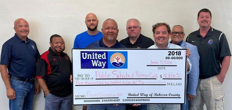 Group of people holding a big check