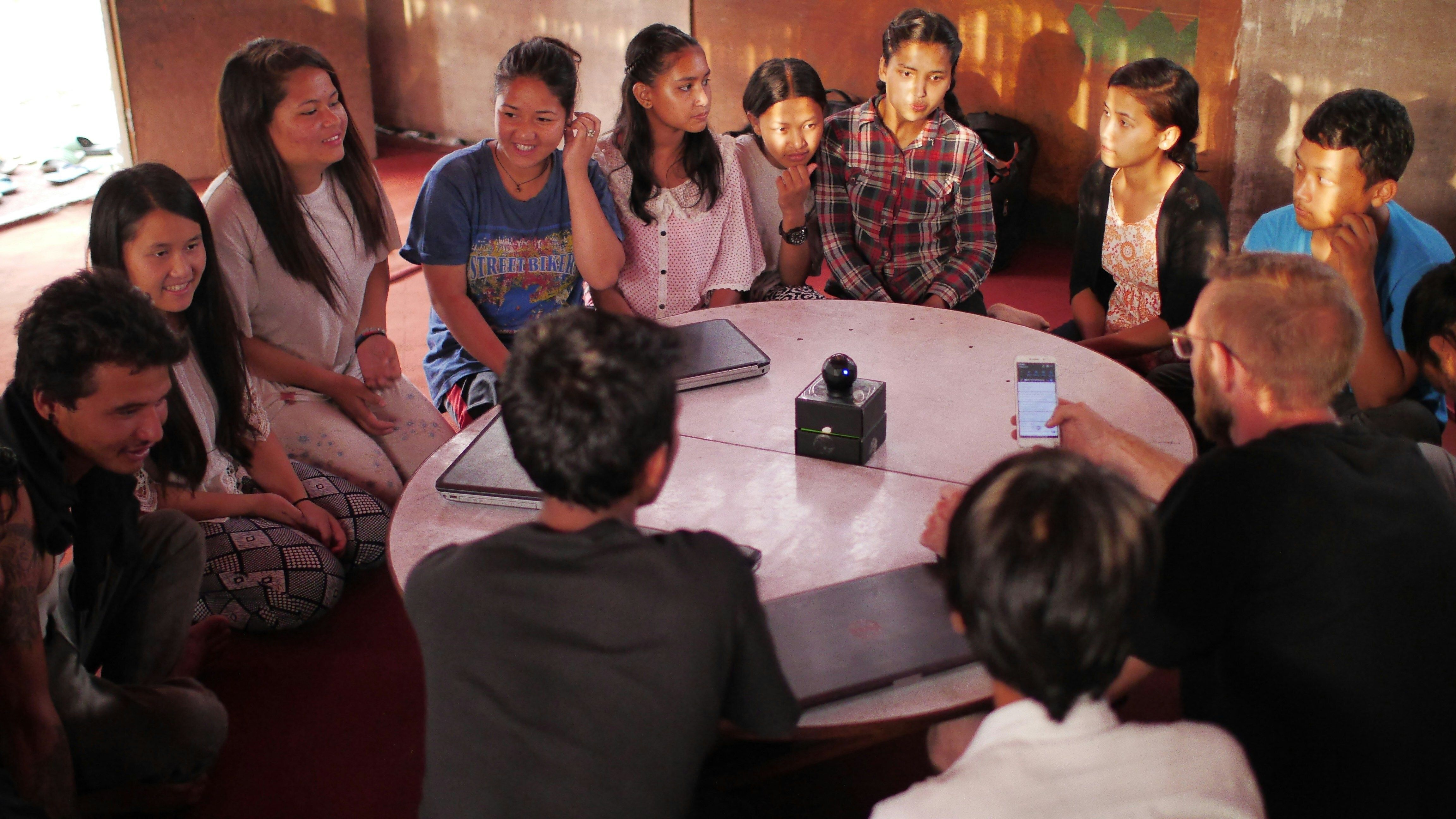 Teenagers sit around a circular table