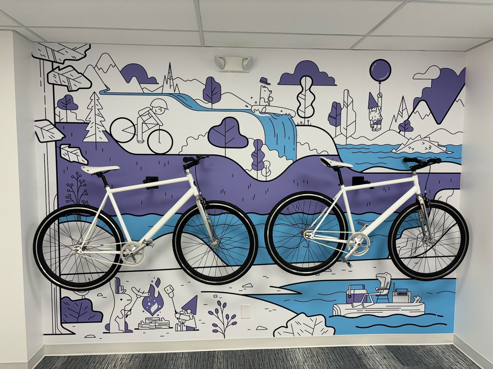 Wall graphic with 2 bicycles on the wall and colorful blue and purple image wall paper.