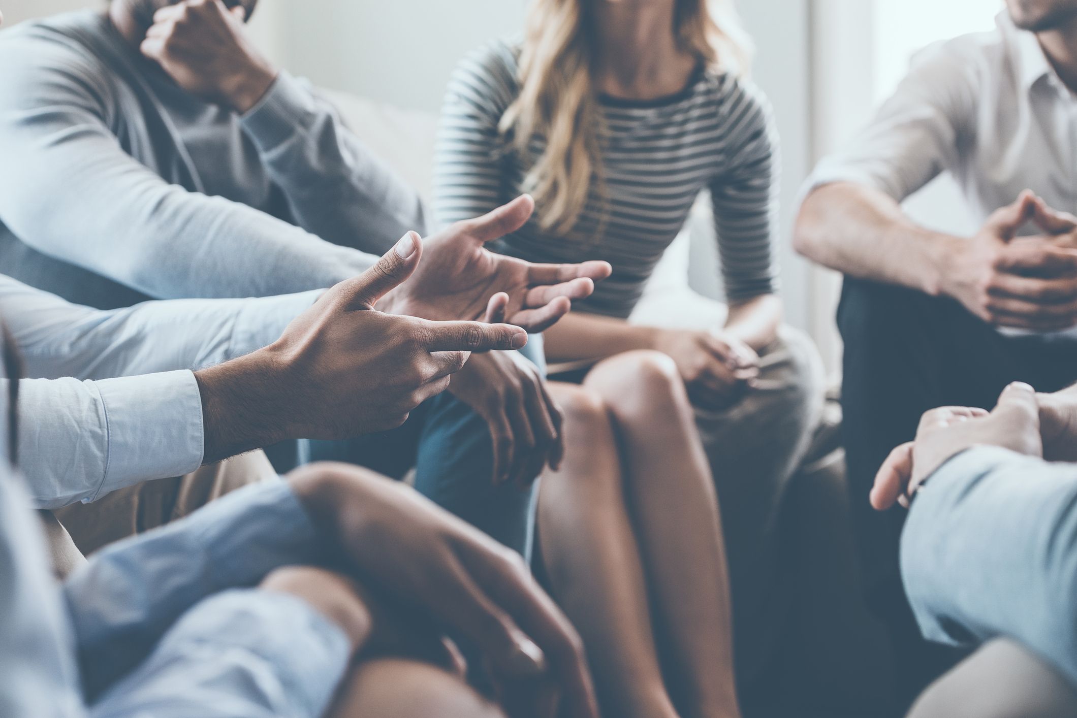 A group of people in a meeting, sitting in a circle.