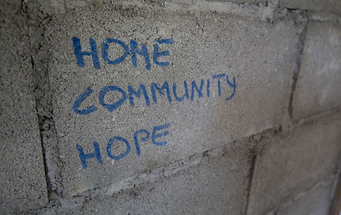 Hope, Community, and Hope written on concrete with chalk.