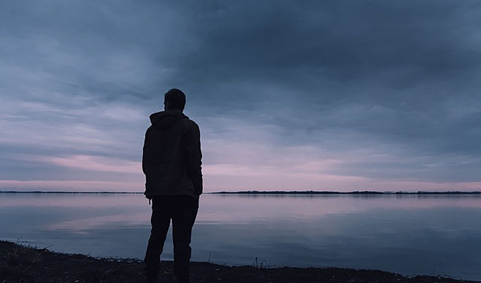 Individual alone looking out over body of water