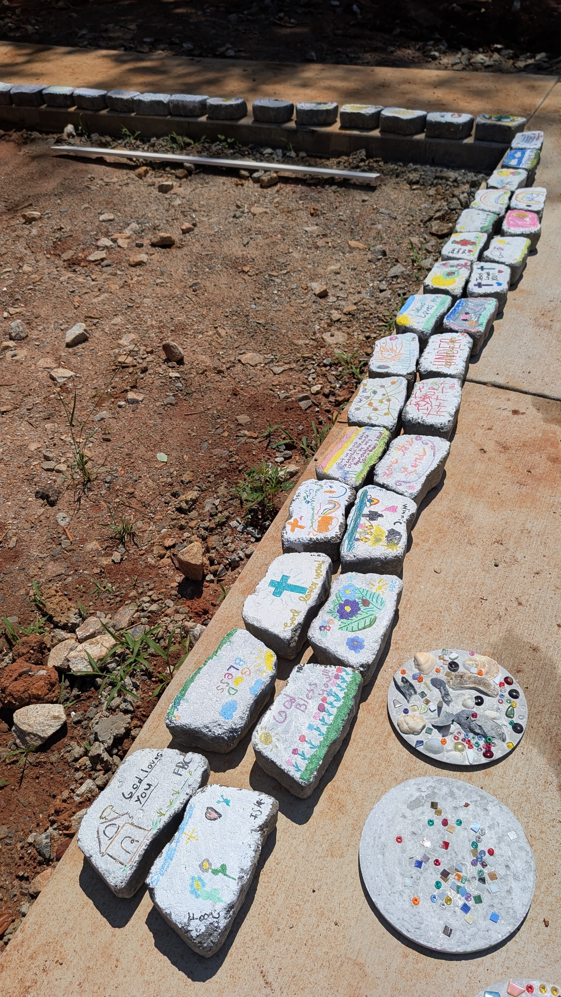 Painted bricks arranged as a border along a garden bed