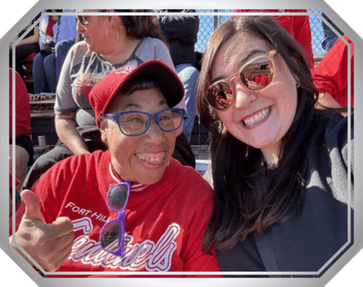 A selfie of two women sitting in bleachers.