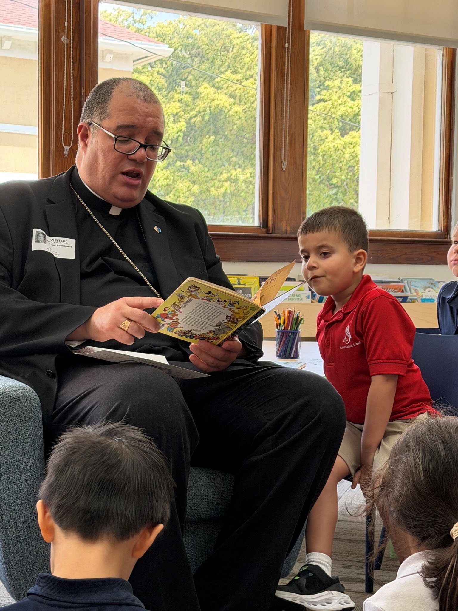 Bishop Manuel reading to students from St. Ann Catholic School