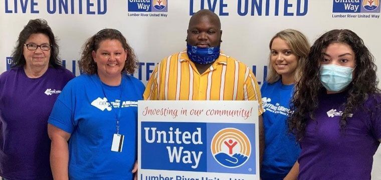 Group of people holding up United Way sign