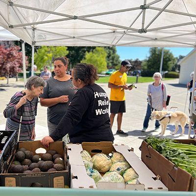 Photo of volunteers giving food to recipients of the Earle Baum Center