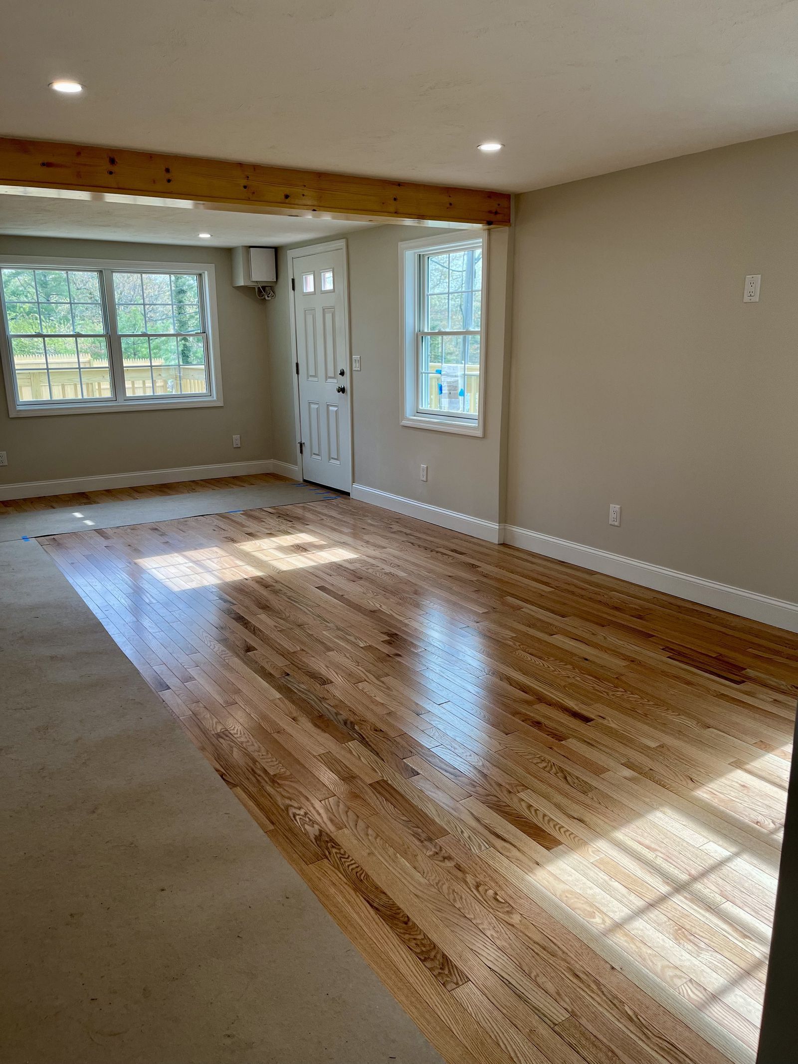 A photo showing an open concept living and dining area with hardwood floors