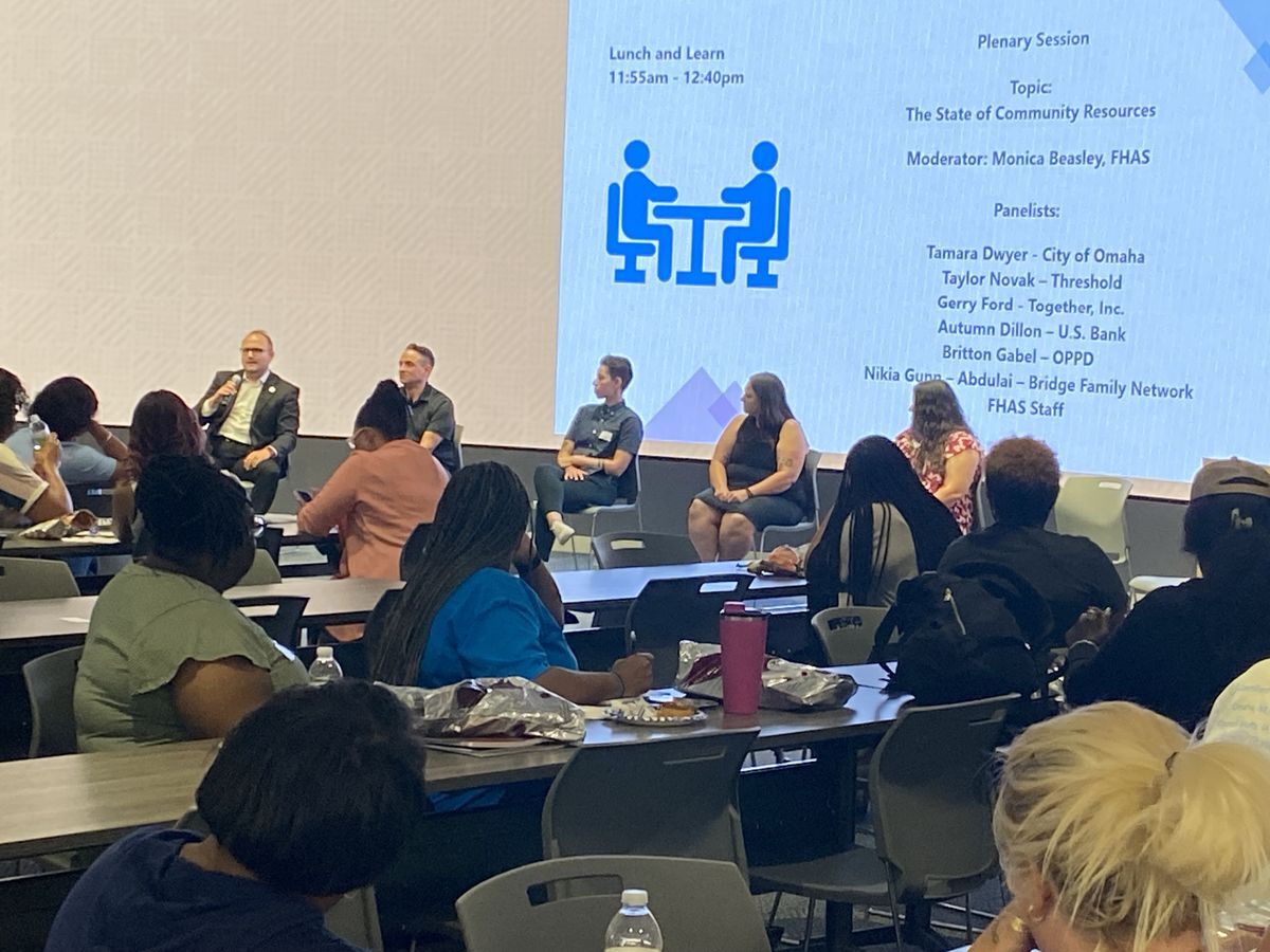 Individuals at tables watching a presentation