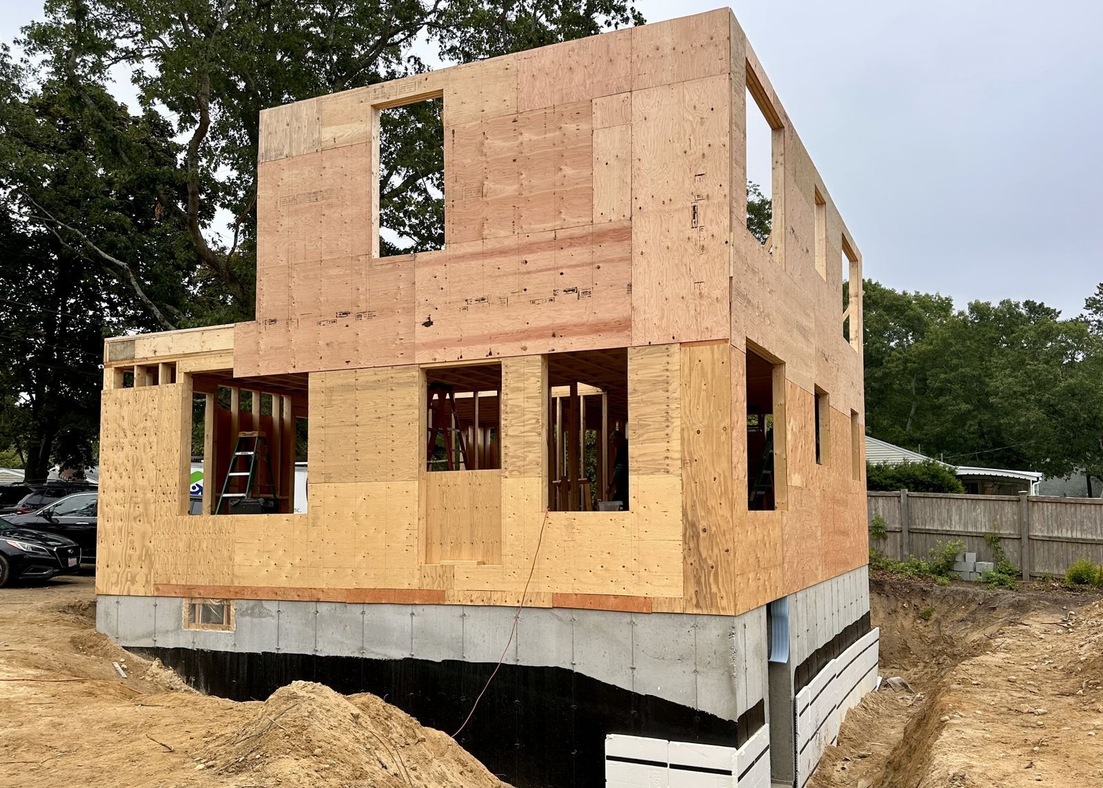 A photo showing the exterior framing and plywood of a two story home