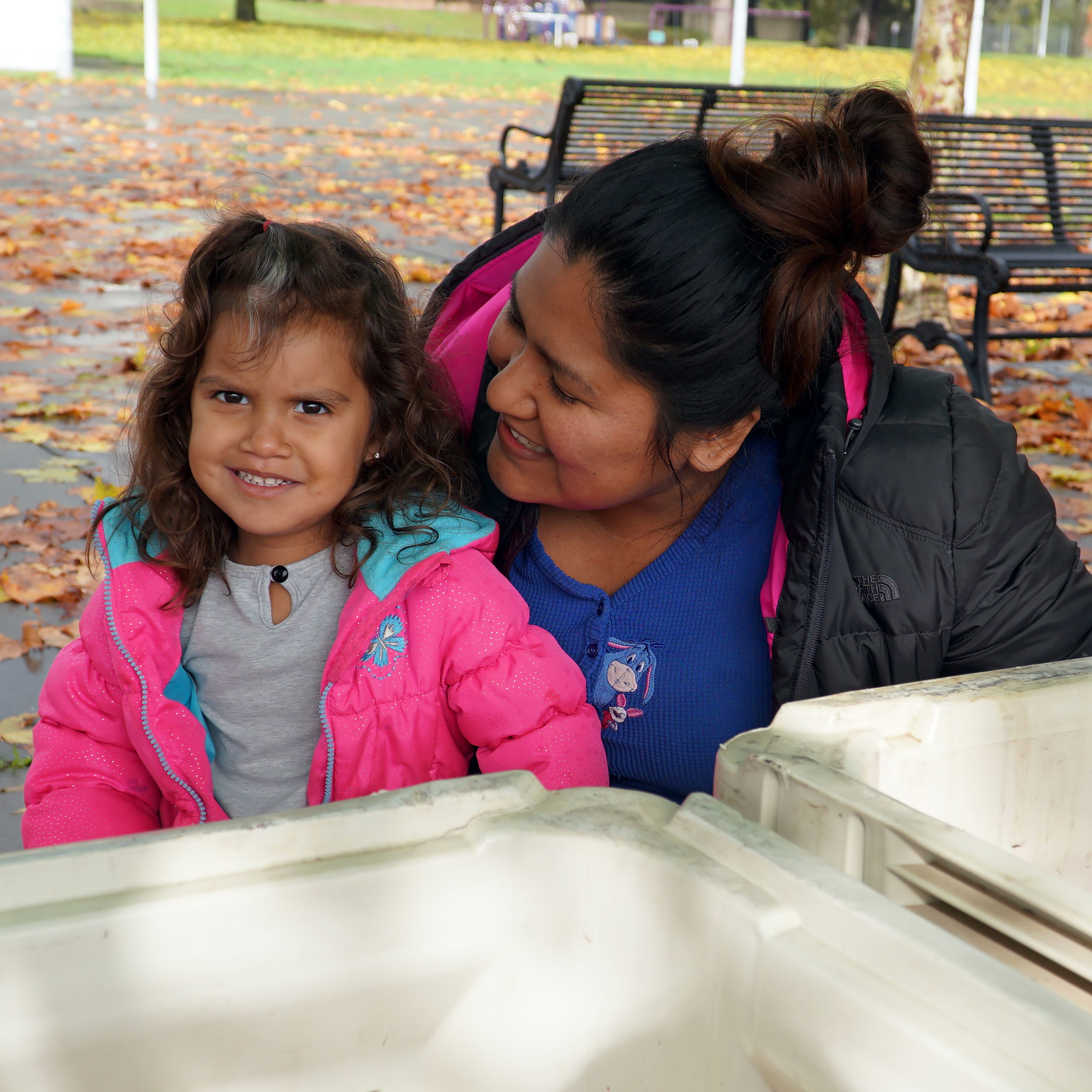 Mother and daughter, both food recipients, smiling