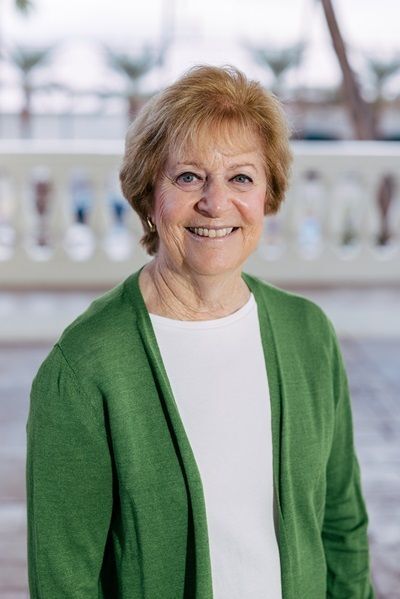 CEO and Founder Ricky Safer smiles at the camera, wearing a brightly colored scarf