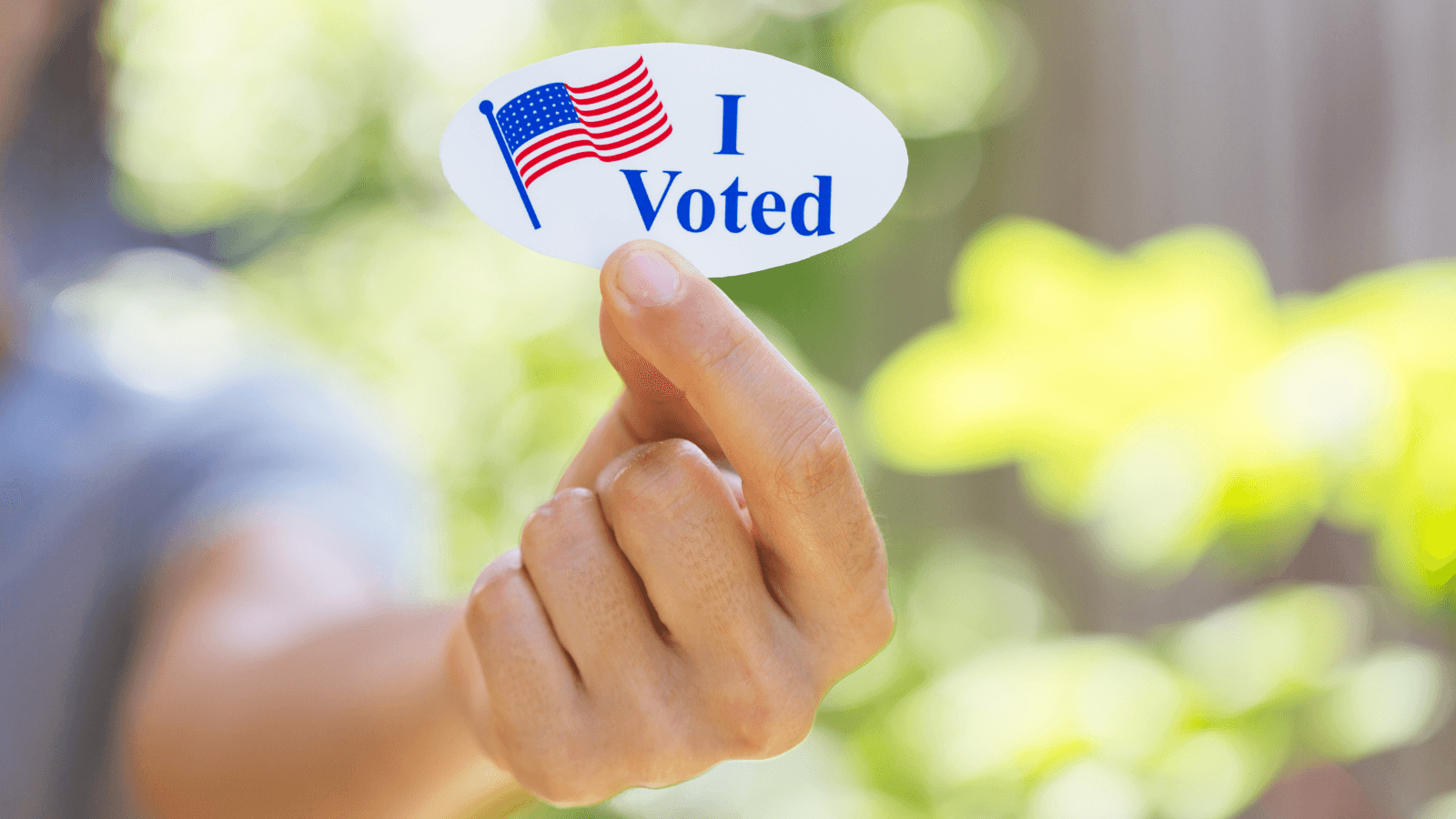 Hand holding "I voted" sticker