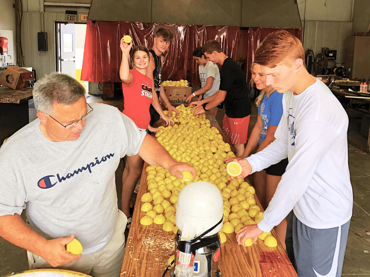 Lee Schroeder and his students process lemons through a lemon squeezer to make lemonade. 