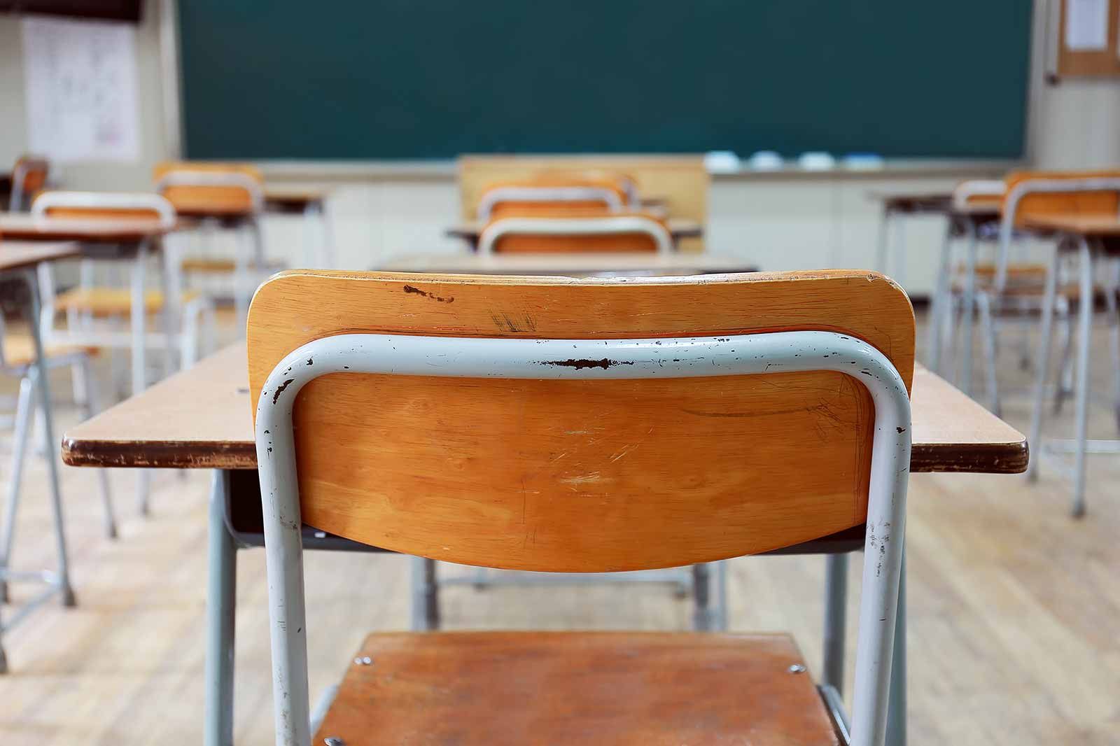 Classroom with desks facing a green chalkboard.