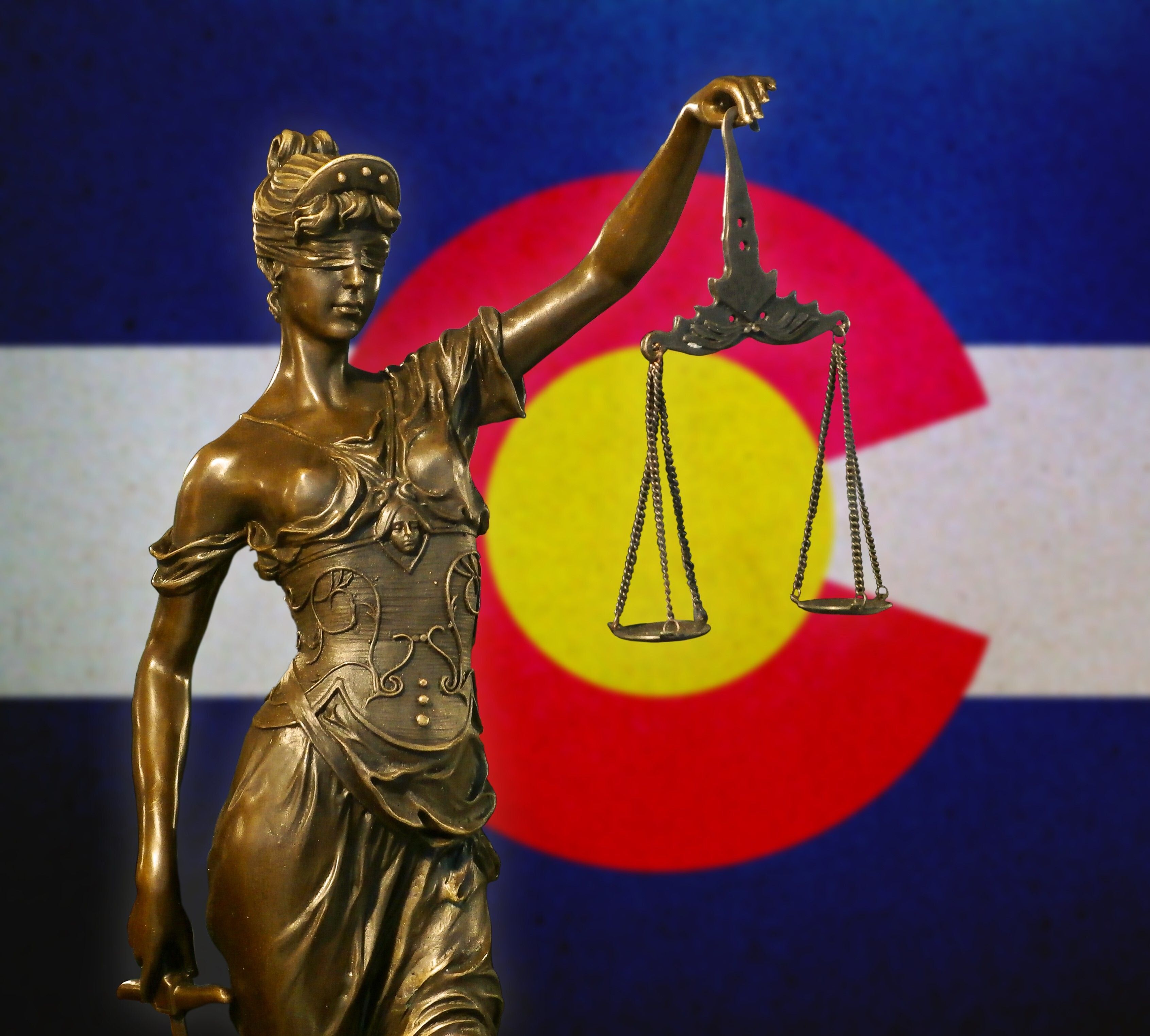 Lady justice in front of Colorado flag