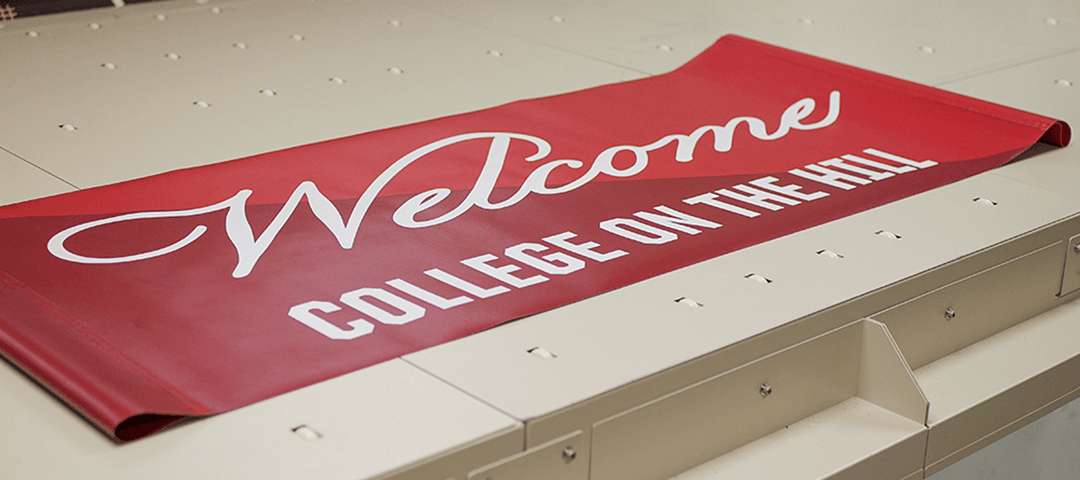 Large format printed vertical pole banner with white text on two-tone red background - Welcome - College on the Hill