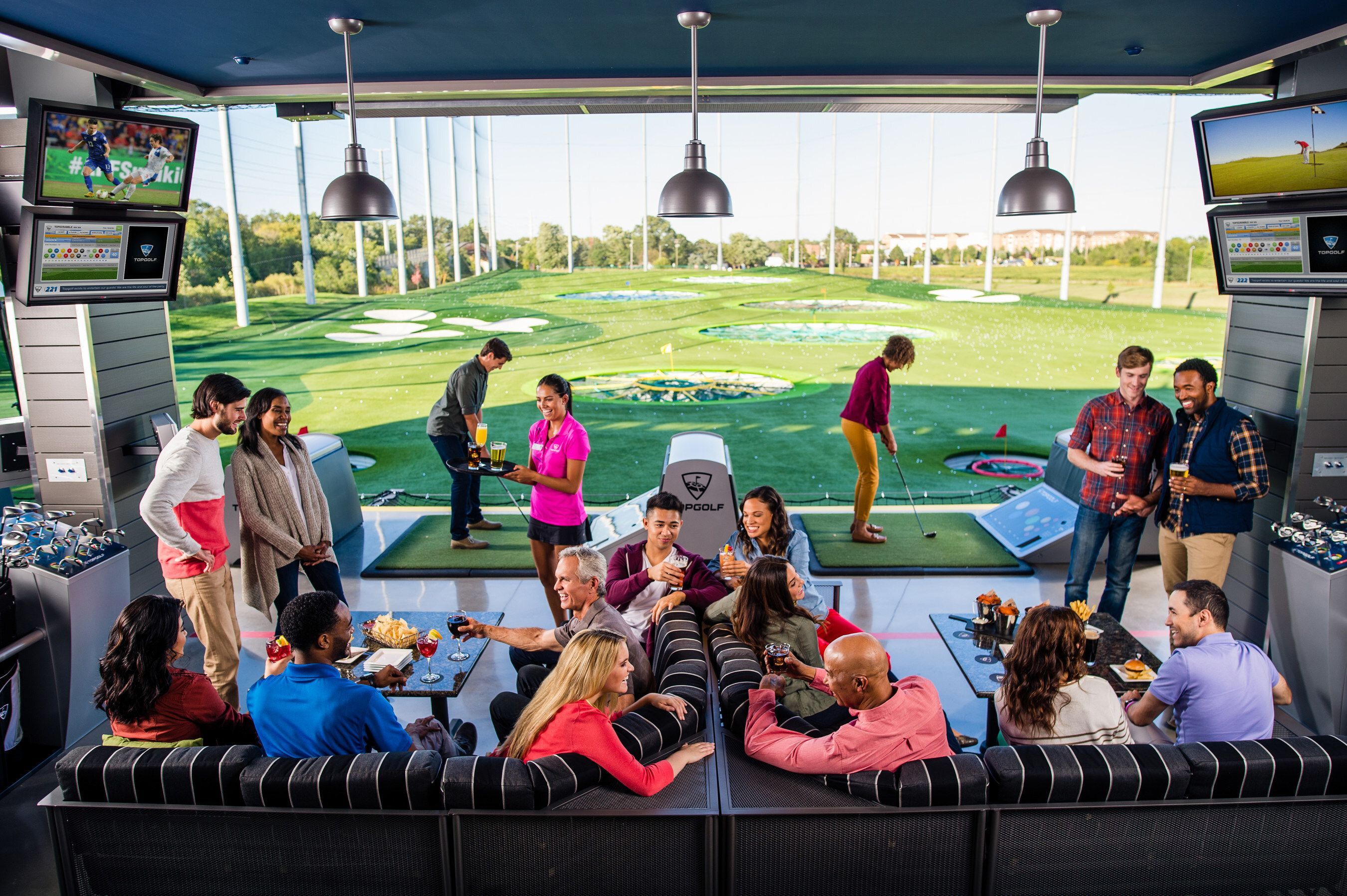 Group of participants at Topgolf sitting and playing golf