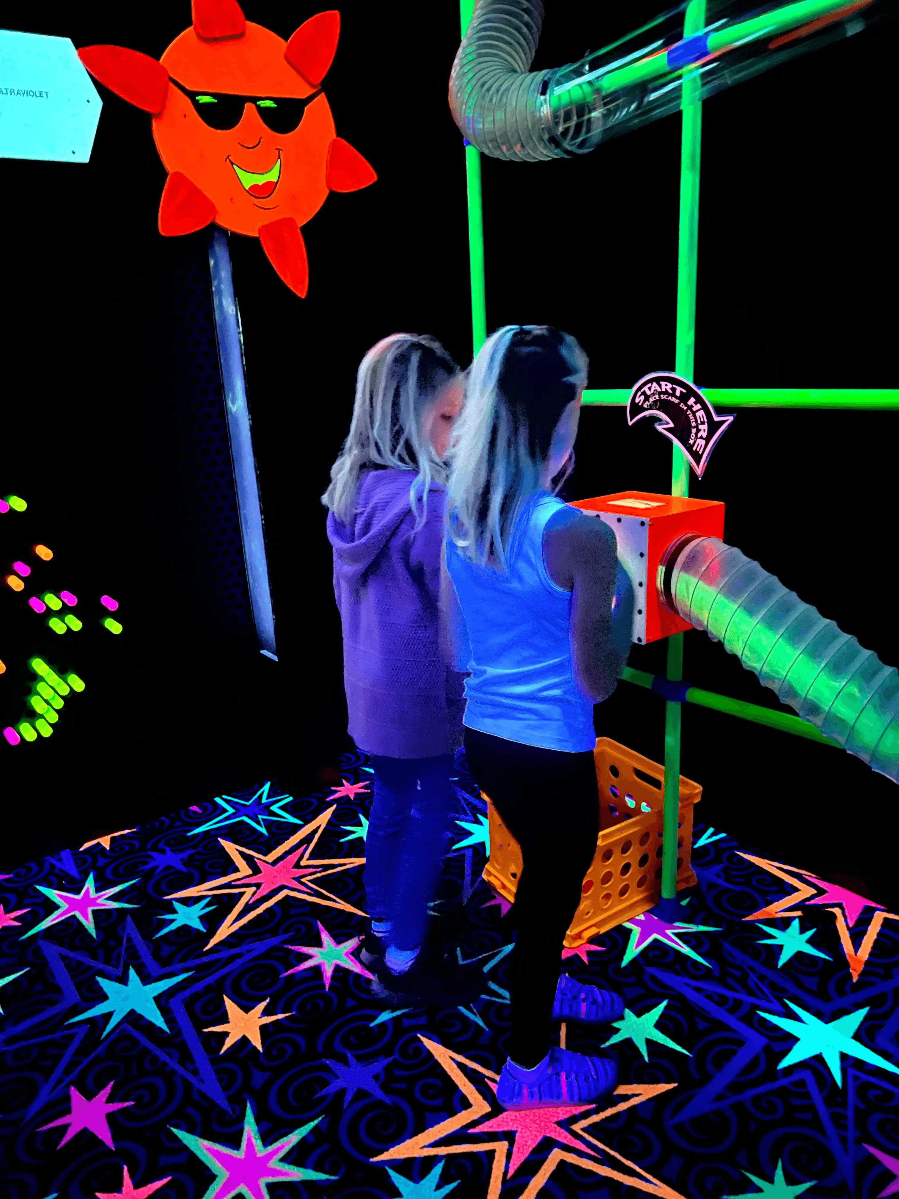 Two children in the blacklight room.