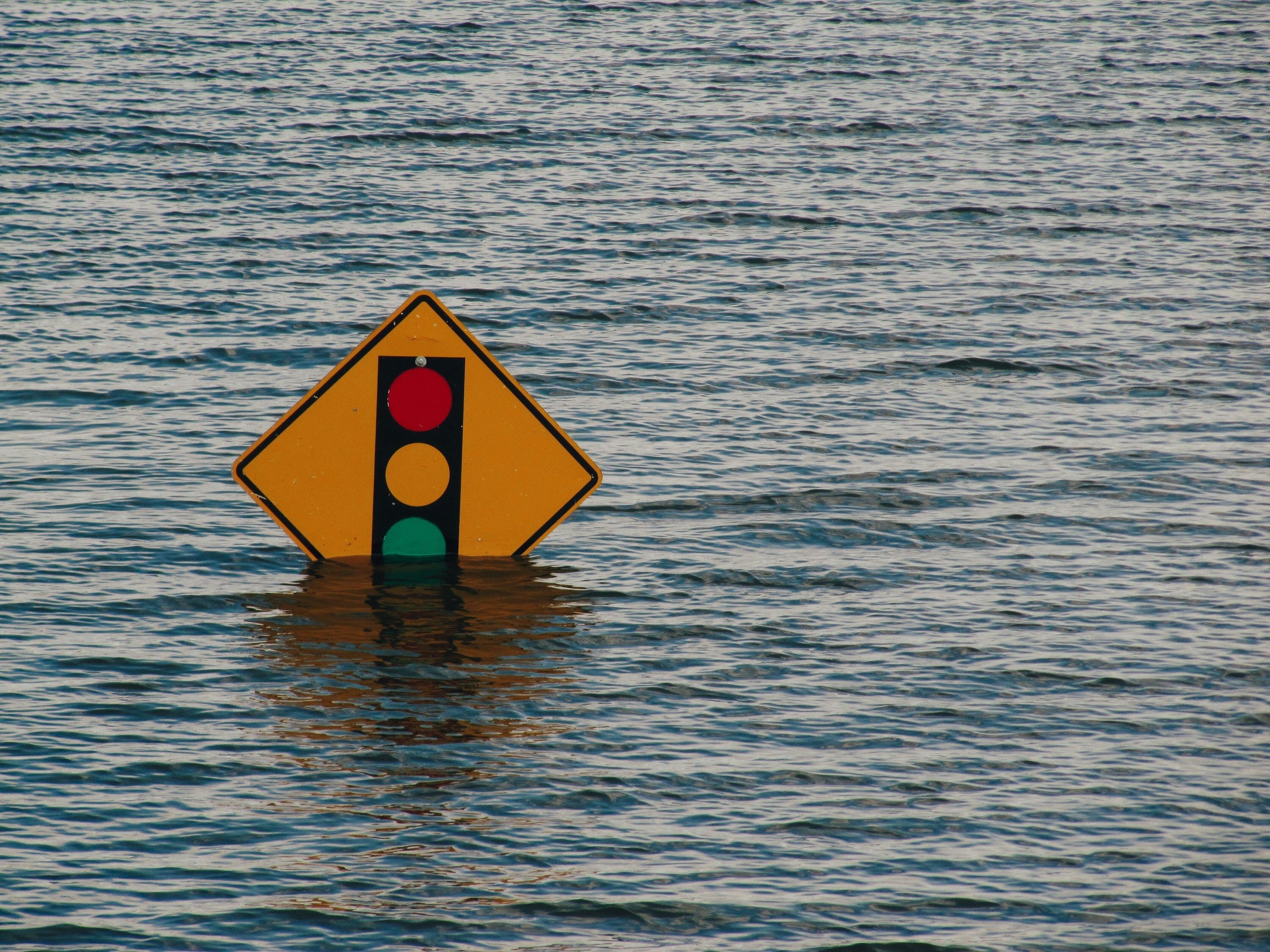 Image credit: Photo by Kelly Sikkema on Unsplash. Picture of traffic light sign in a body of water.