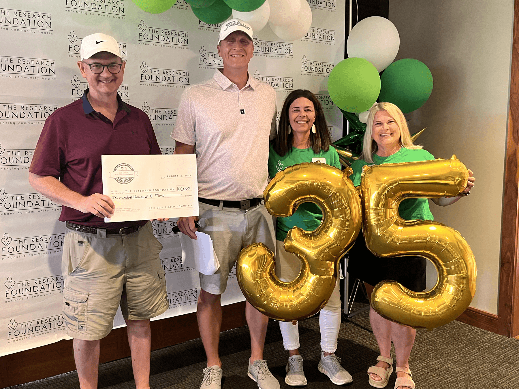 Accepting check for Research Golf Classic