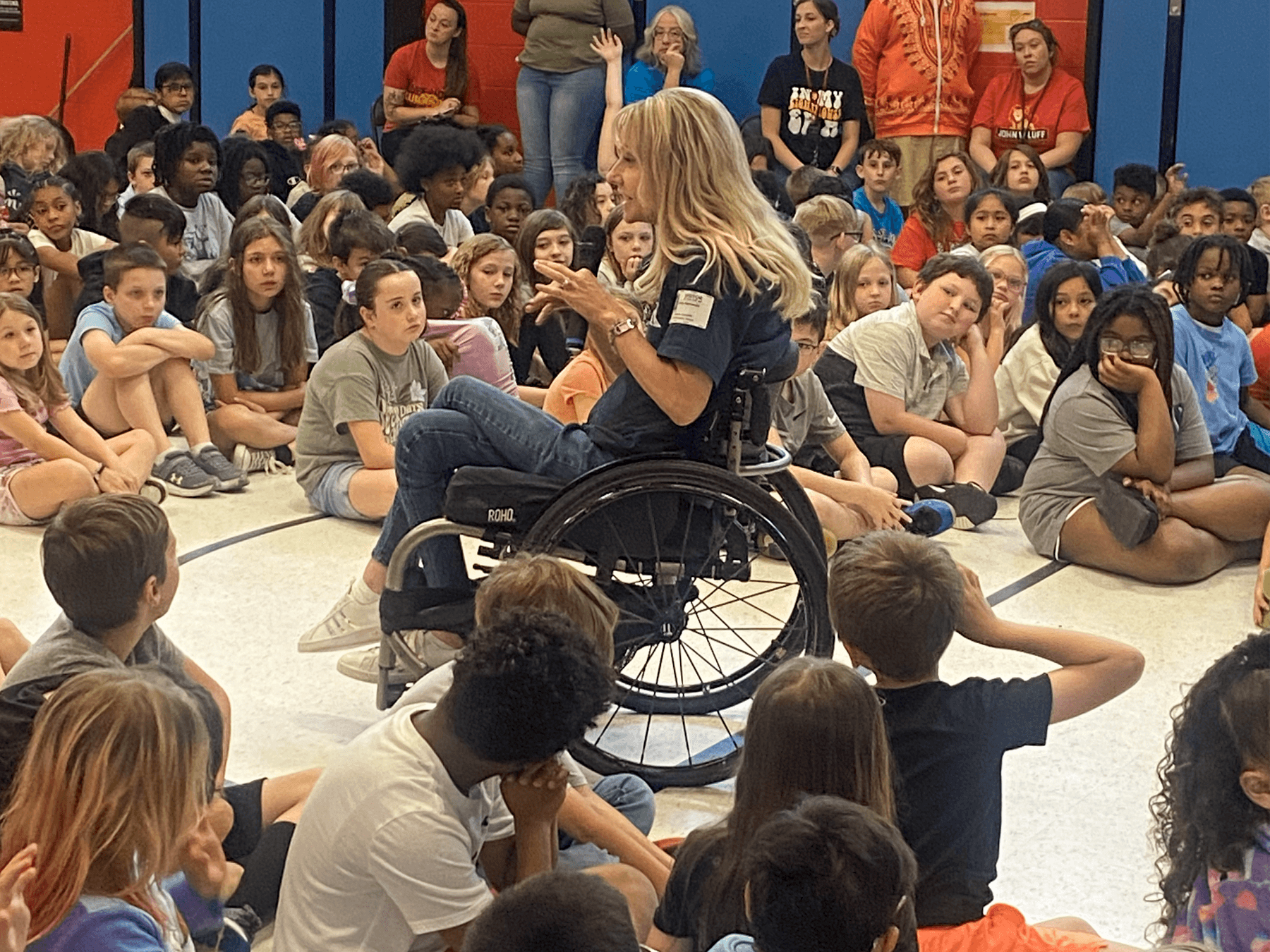 woman in wheel chair speaking to students