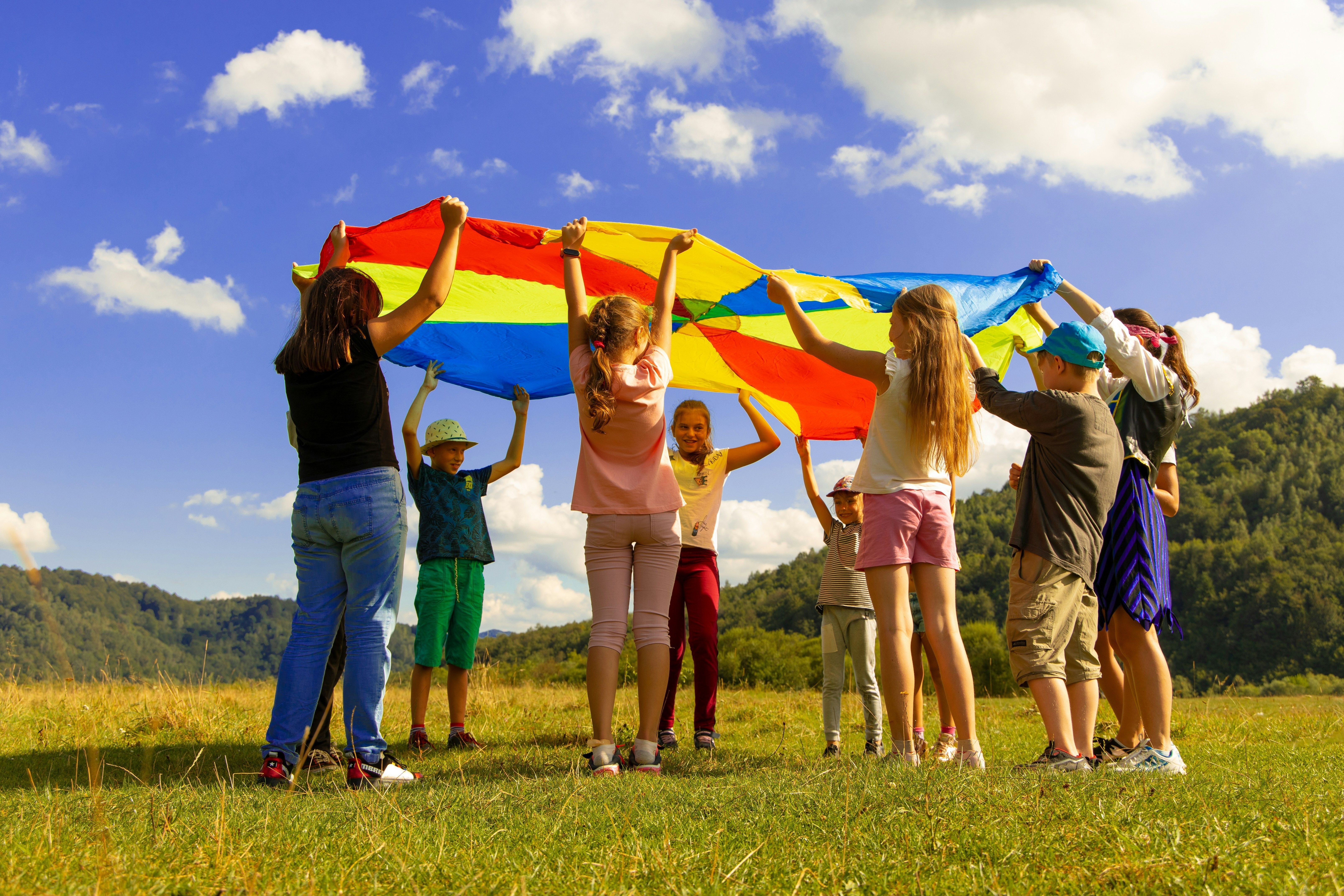 five smiling children of diverse races and genders lying in the grass under the Georgia Center for Child Advocacy logo