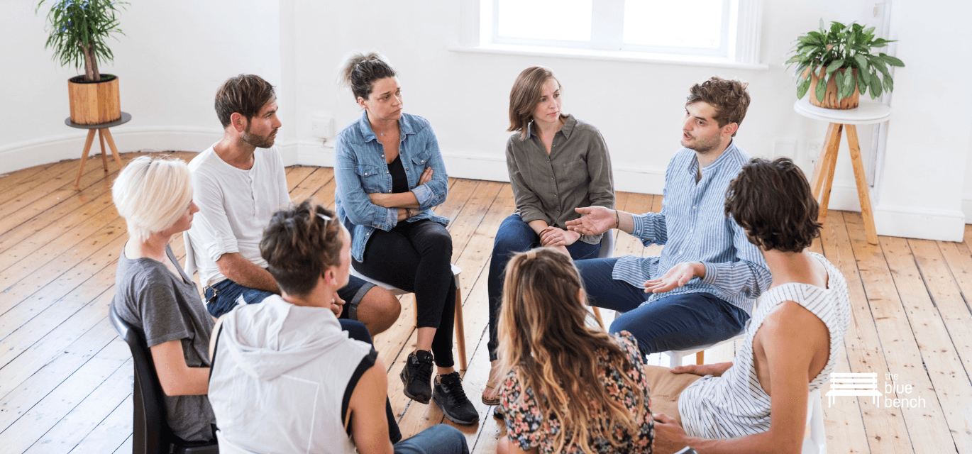 Photo of group sitting in a circle talking 