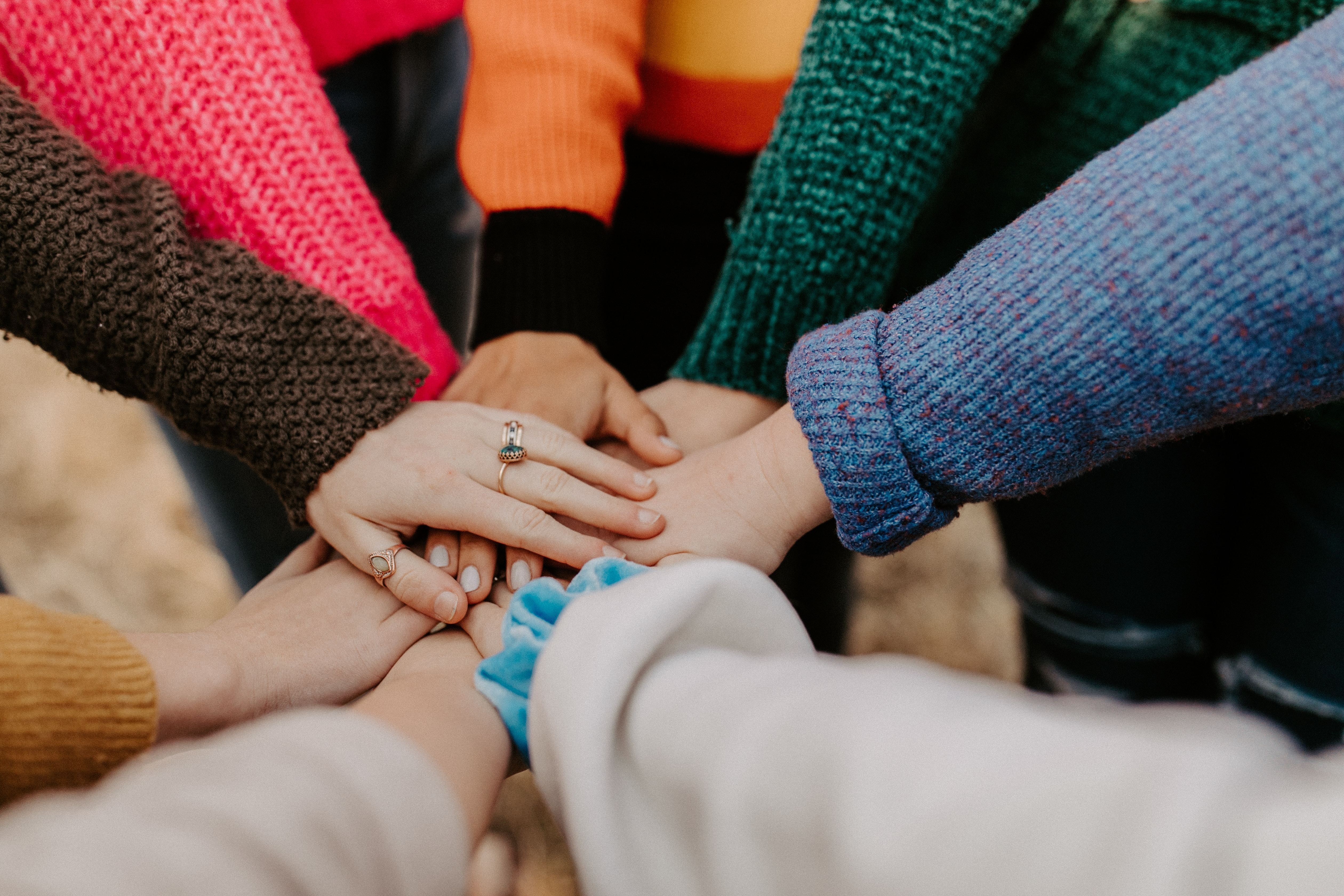 Circle of arms putting hands out to touch together