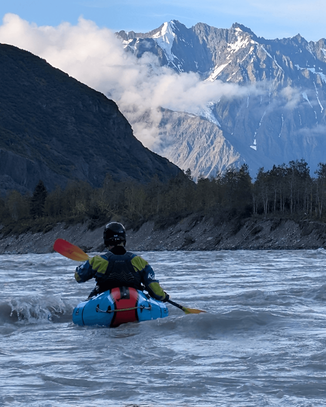 Photo paddling in Alaska with mountains in the background.