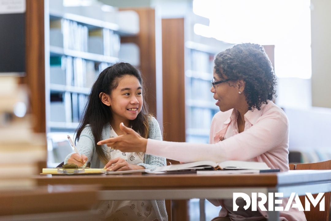 Two girls sitting at a table in a library