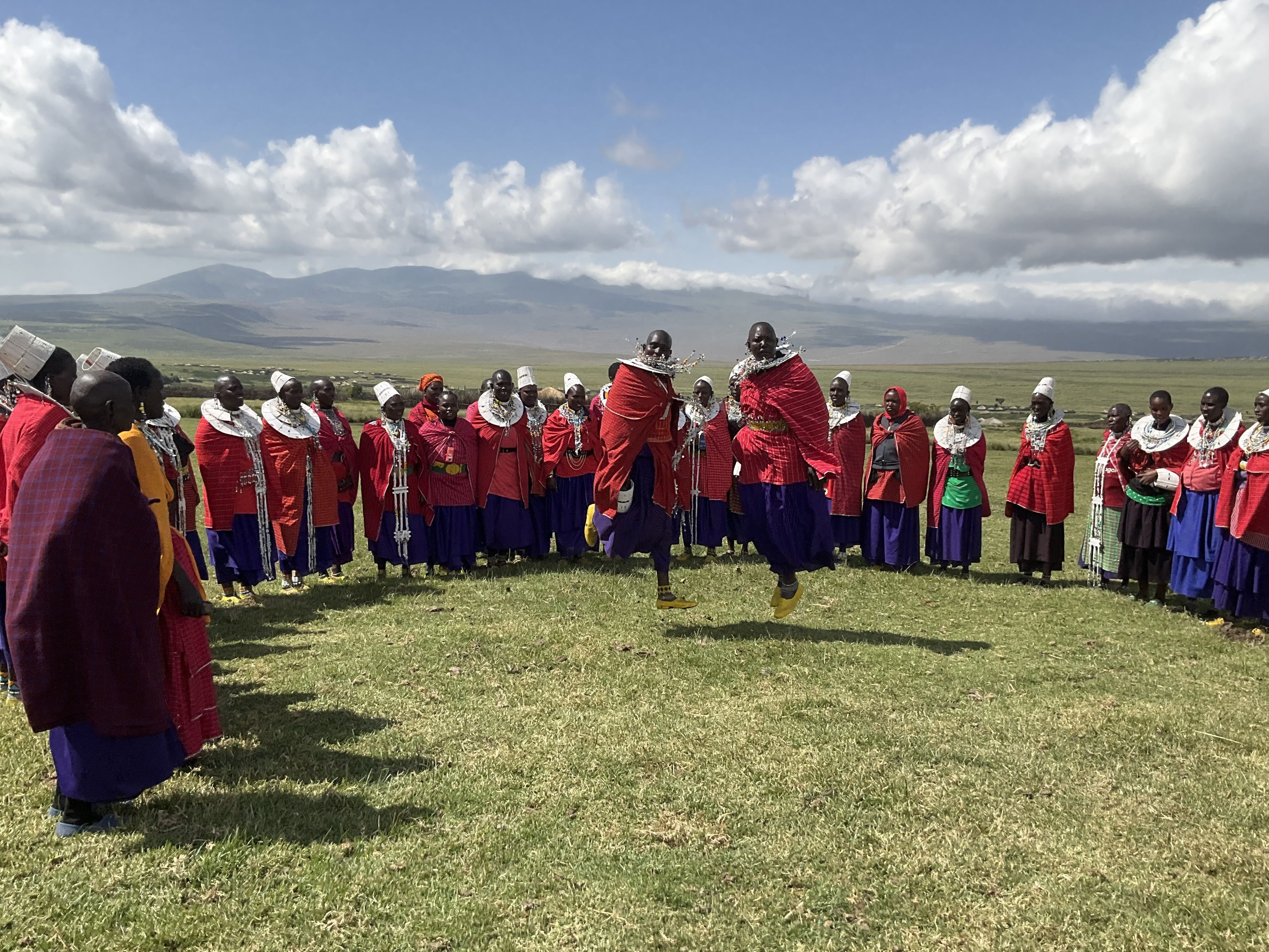 Maasai community members in traditional clothing celebrate with dancing in the Ngorongoro highlands of Tanzania.