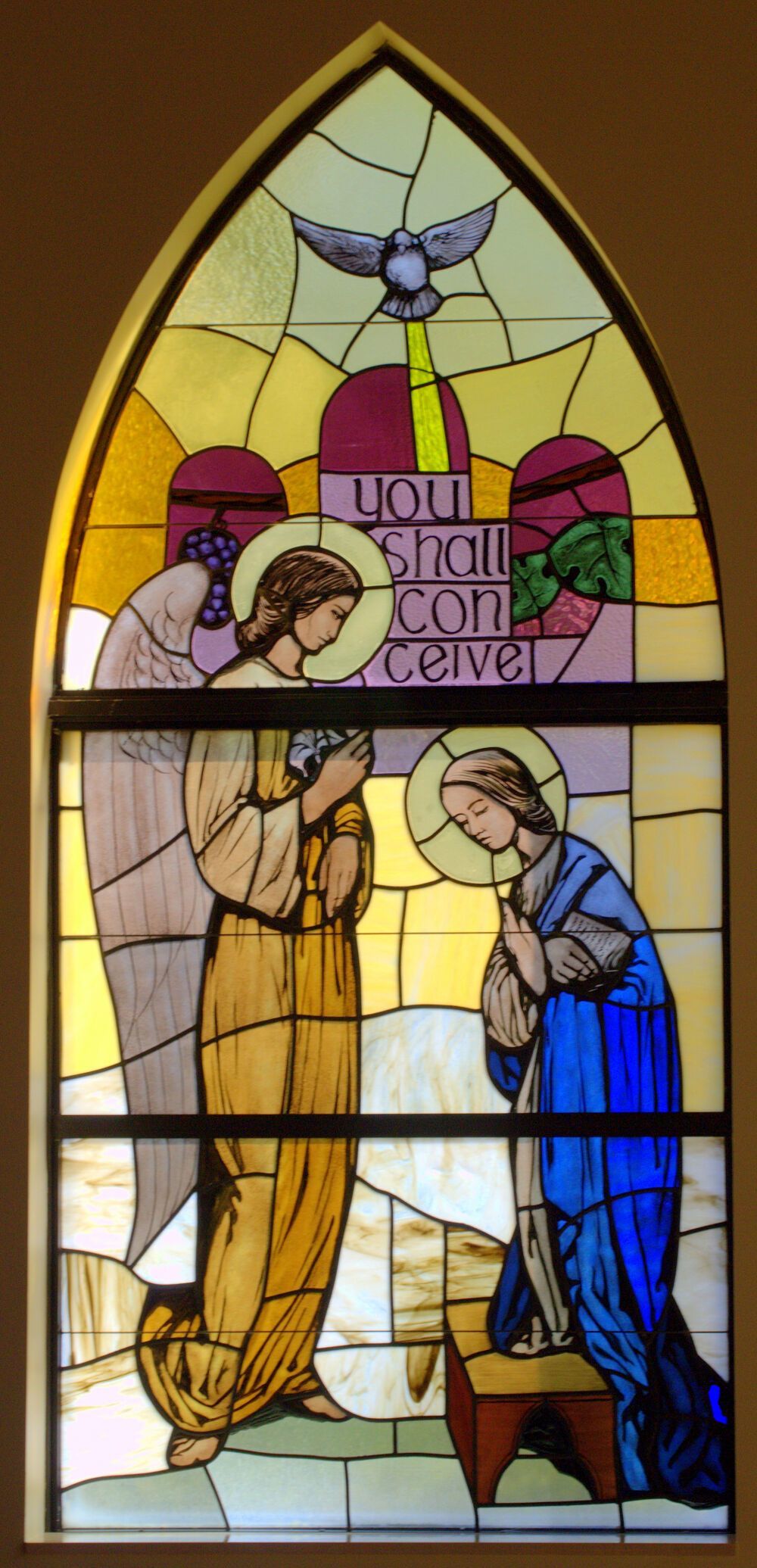 Gabriel announces to Mary that she will conceive the Son of God in this window at St. Patrick's Church, Palm Beach Gardens. The Holy Spirit overshadows her as a dove.