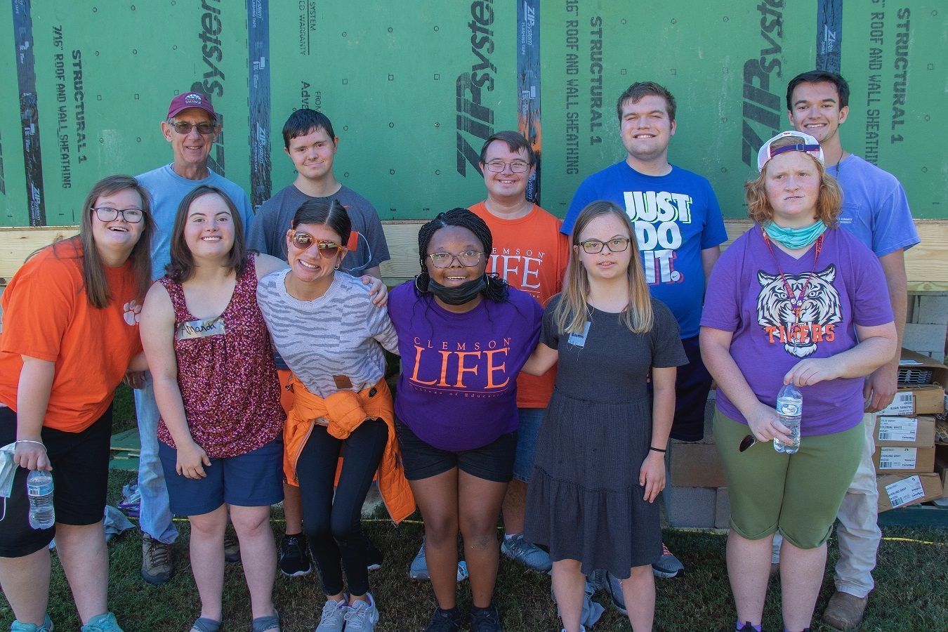 Clemson LIFE students pose as a group in front of the 2021 Homecoming Build on Bowman Field